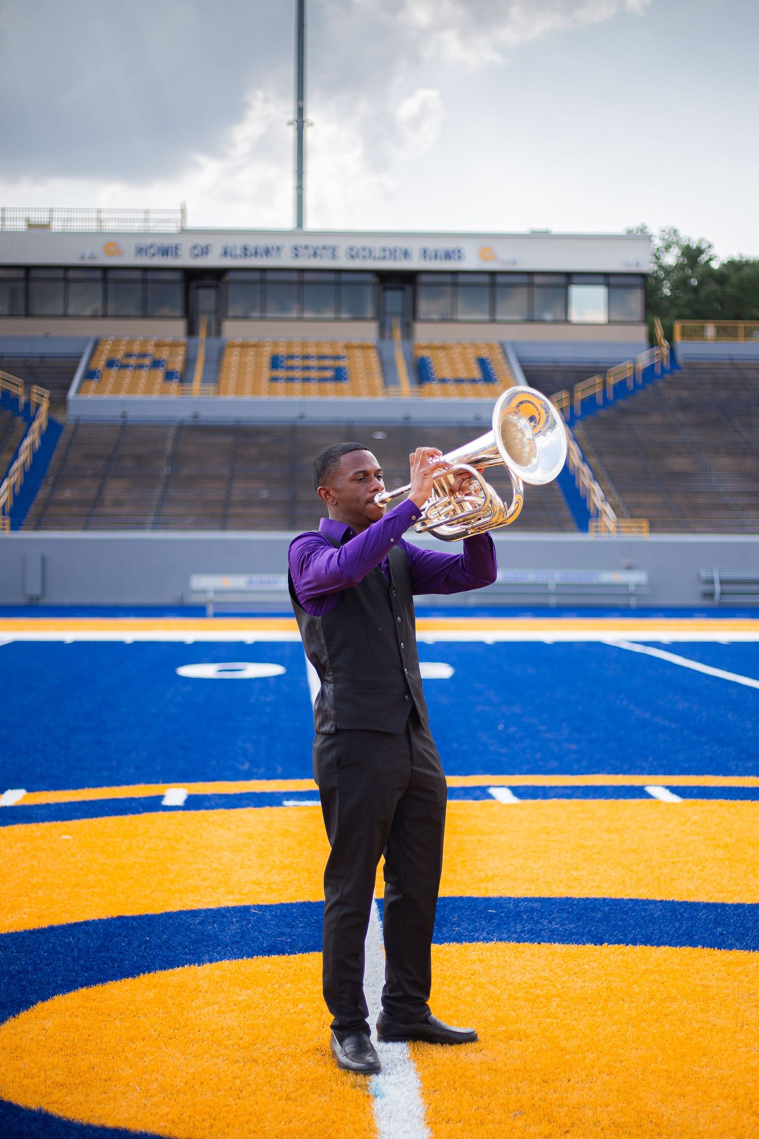 university band graduate with instruments in football field