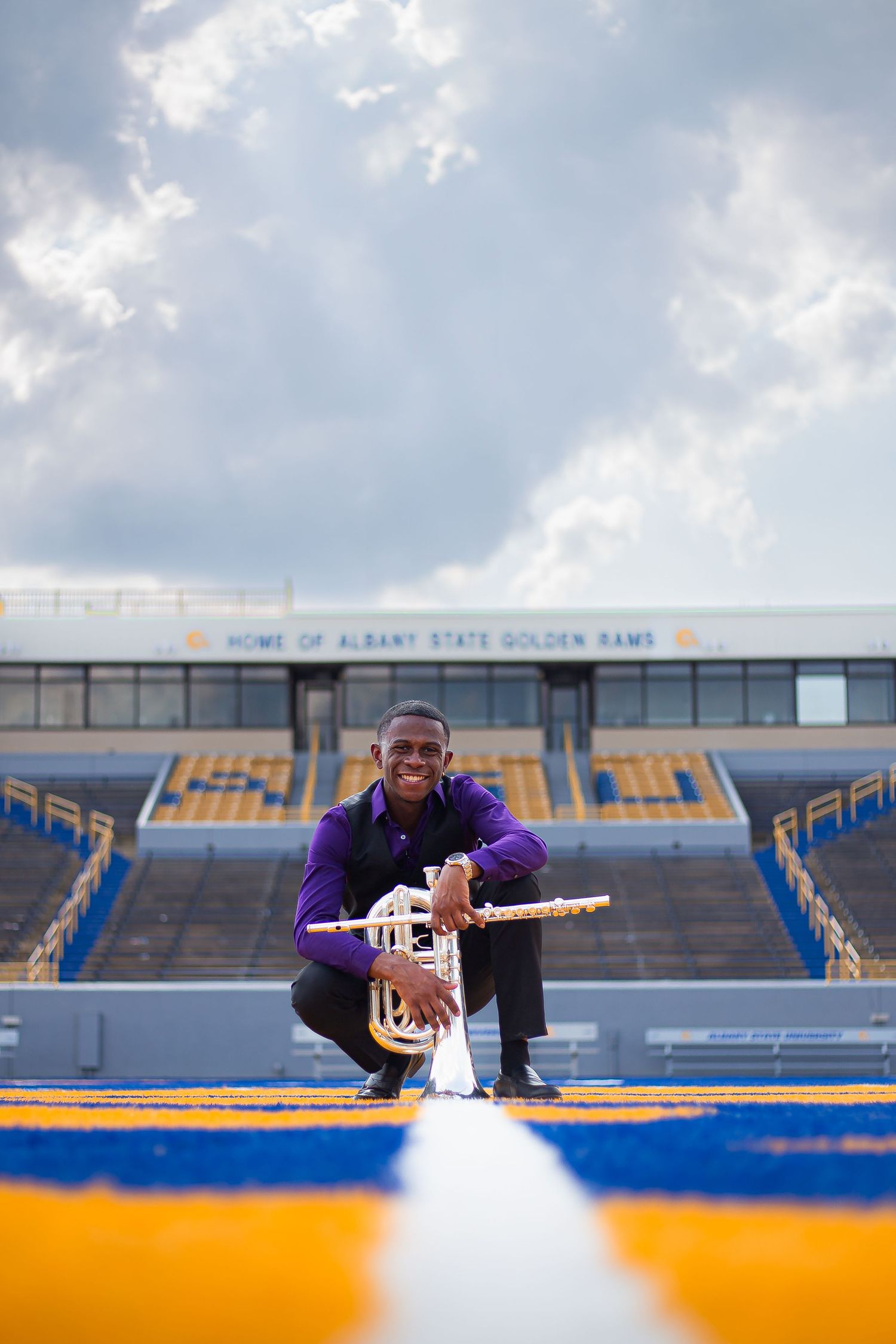 university band graduate with multiple instruments in football field
