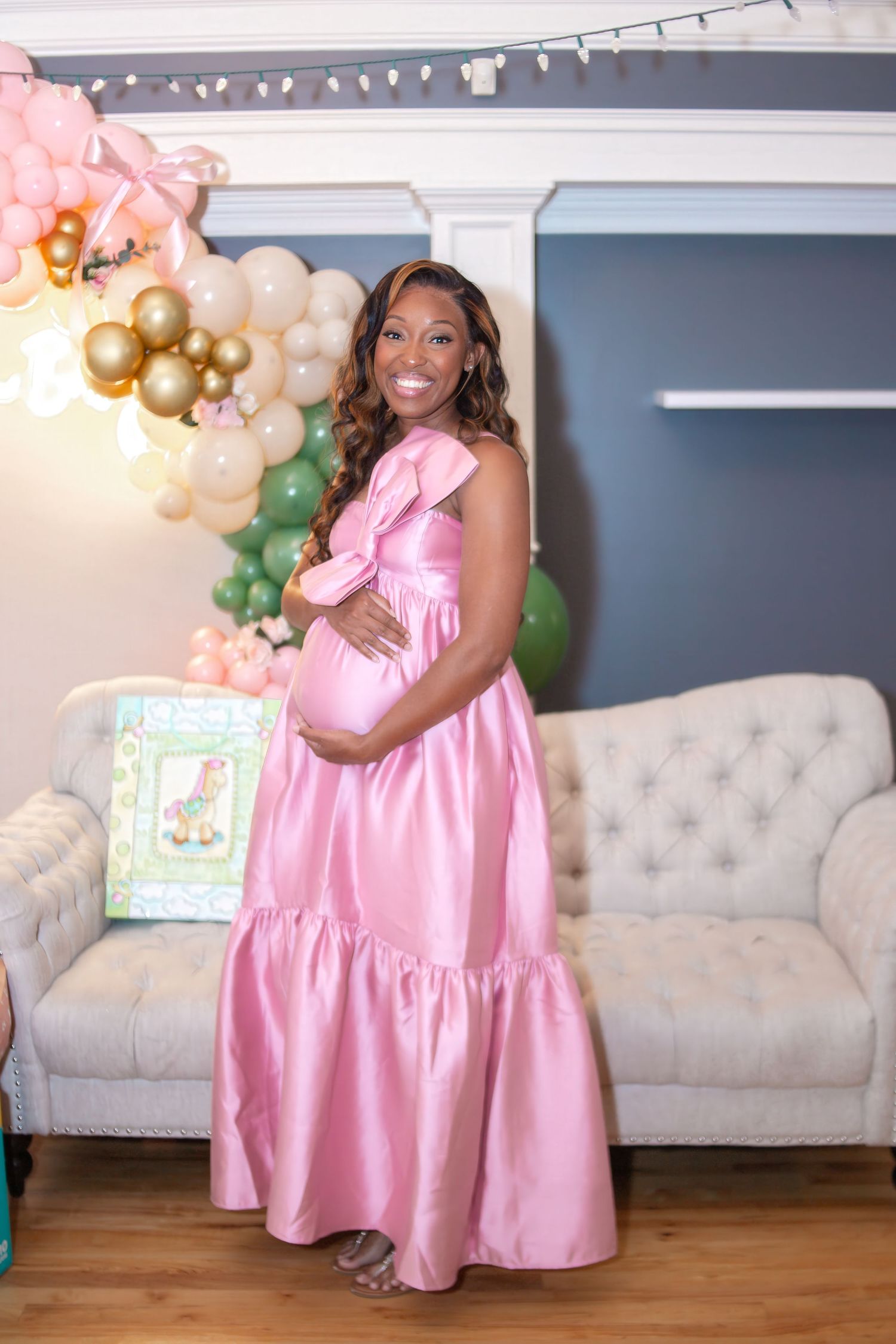 pregnant woman holding belly wearing pink flowy dress