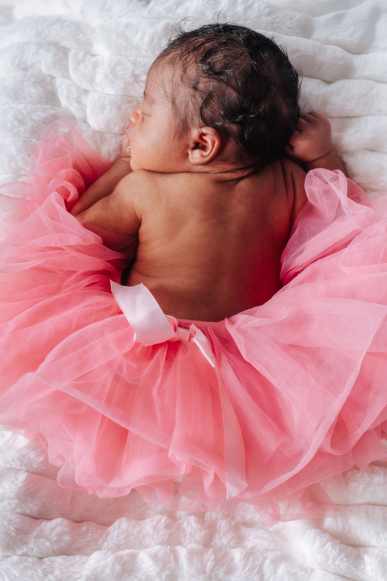newborn with pink skirt