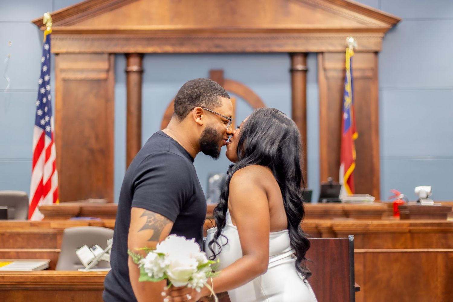 young couple kissing in court room in front of judge