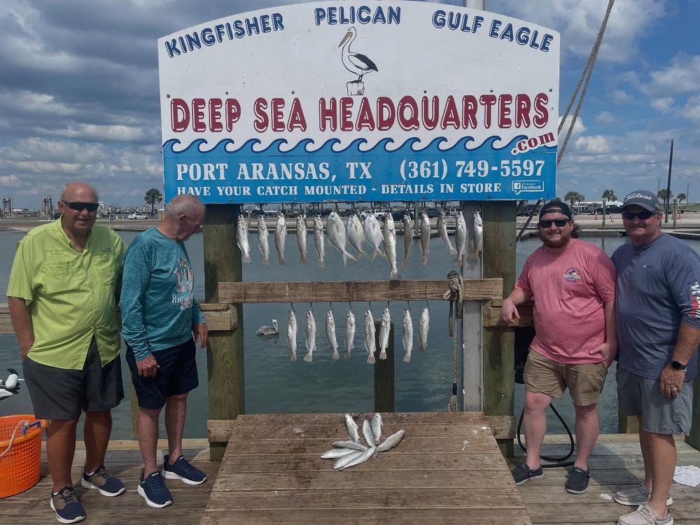 Four anglers displaying kingfish catch at Deep Sea Headquarters in Port Aransas Texas.