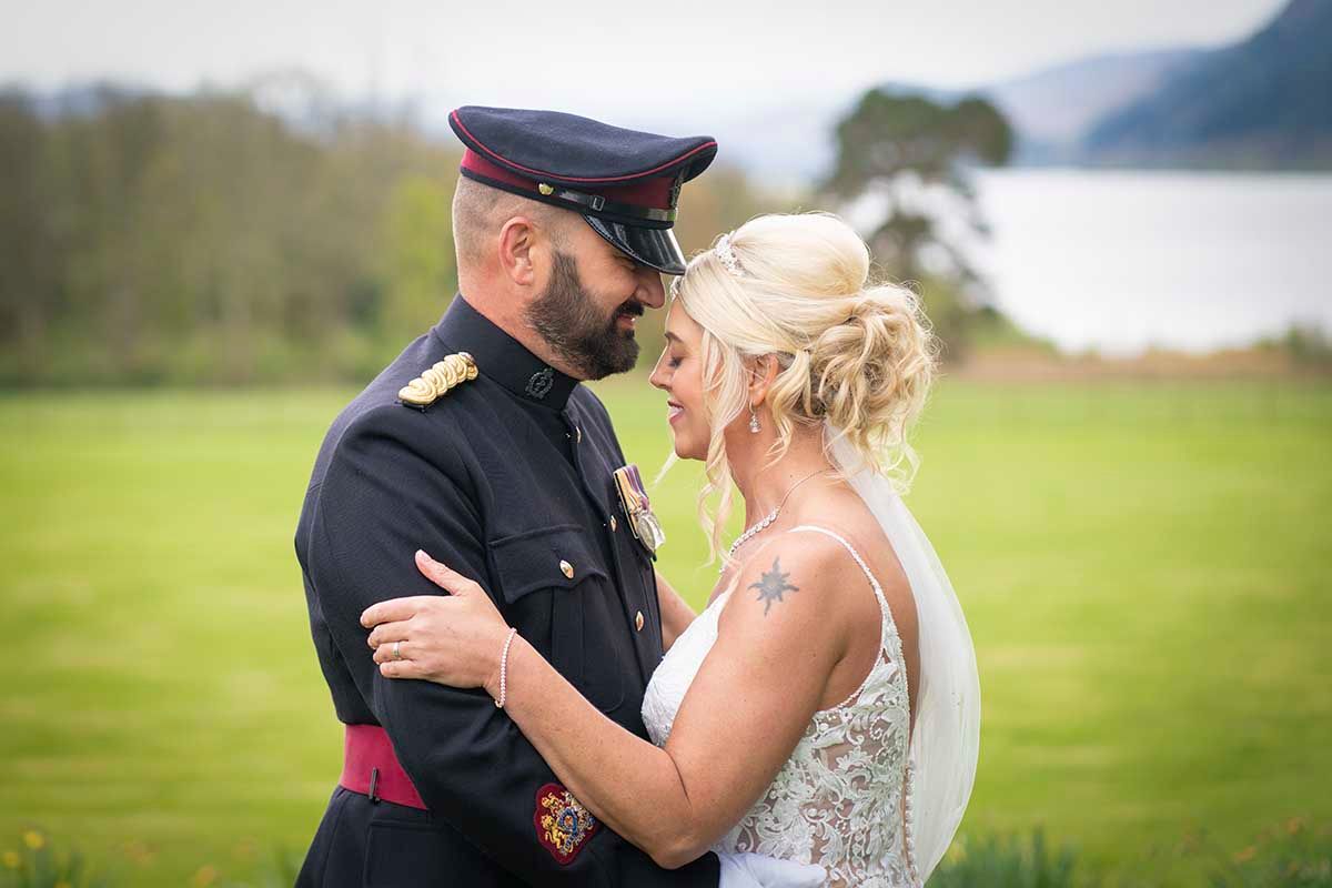 soldier and his bride pose for wedding photos at Armathwaite Hall -Keswick, one of the lake districts premier wedding venues.