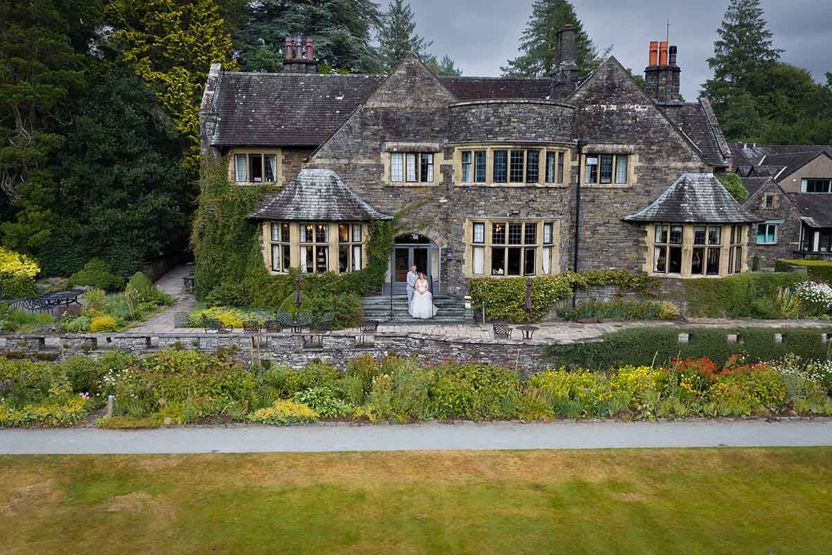 Bride and groom standing outside cragwood country house wedding venue in the lake district