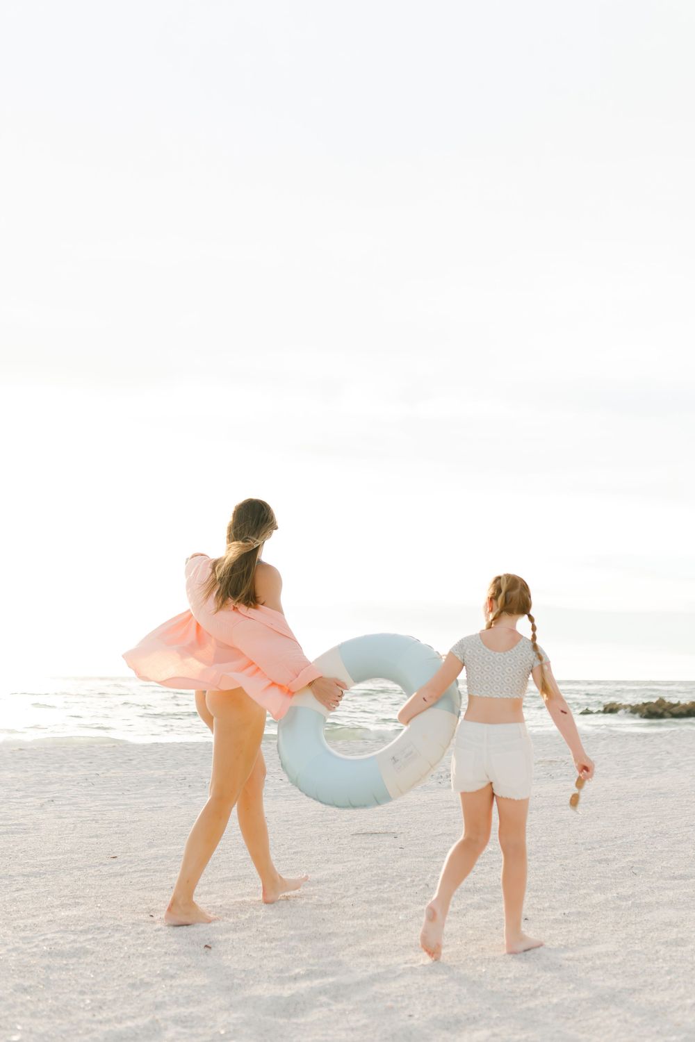mom and daughter walking on beach in Florida, photo taken by Erika Adams Photography