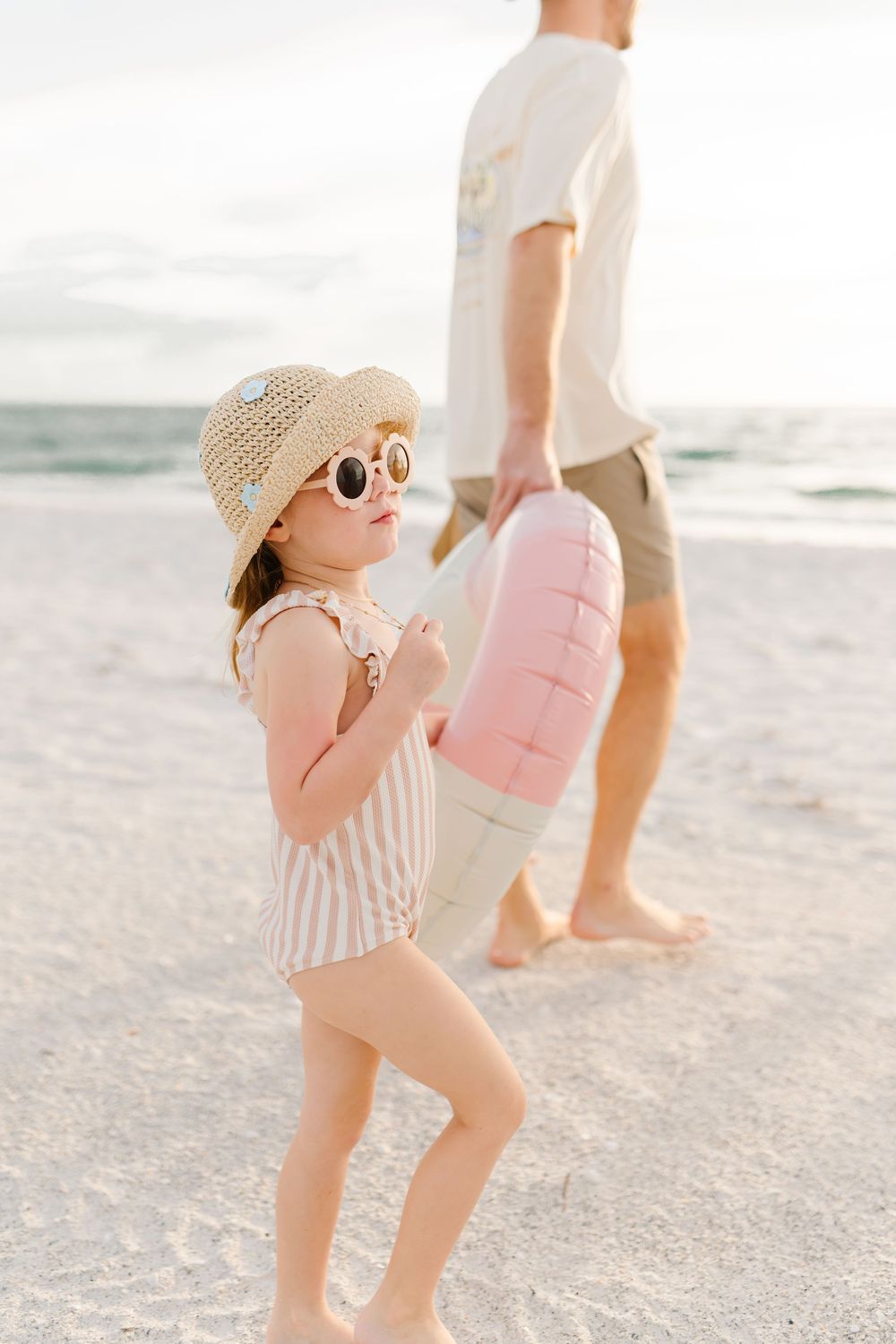 girl with fun sunglasses walking on beach during photoshoot with dad