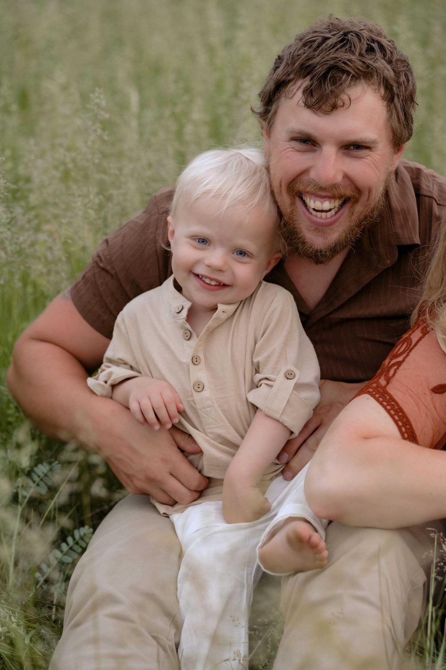 Dad tickling toddler son during outdoor family photos in Hudson, WI.
