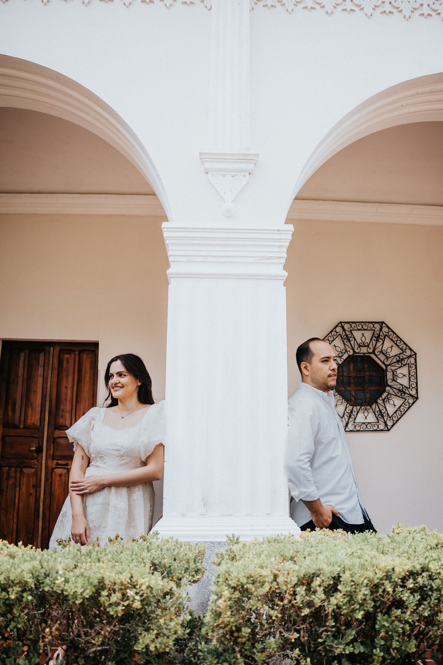 Pareja posando bajo arcos coloniales en Antigua Guatemala durante sesión de Save the Date / Couple posing under colonial arches in Antigua G