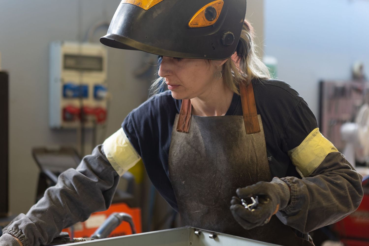 Lavoratrice al lavoro in officina con dispositivi di protezione