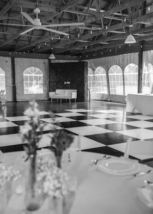 Details of wedding reception that include, linen, serving utensils, butter yellow napkins, and a checkered dance floor in Sherwood, MI