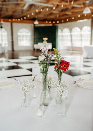 Details of wedding reception that include, linen, serving utensils, butter yellow napkins, and wild flower decor in Sherwood, MI