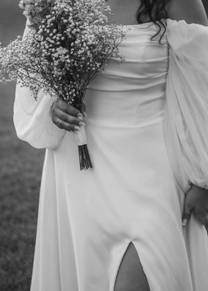 Black and White photo of details of bride with bouquet and holding dress in Sherwood,MI