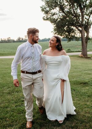 Bride and groom walking hand in hand at sunset in Sherwood,MI