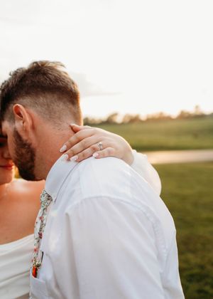 Bride and groom, with engagement ring and wedding ring clear in photo at sunset in Sherwood,MI