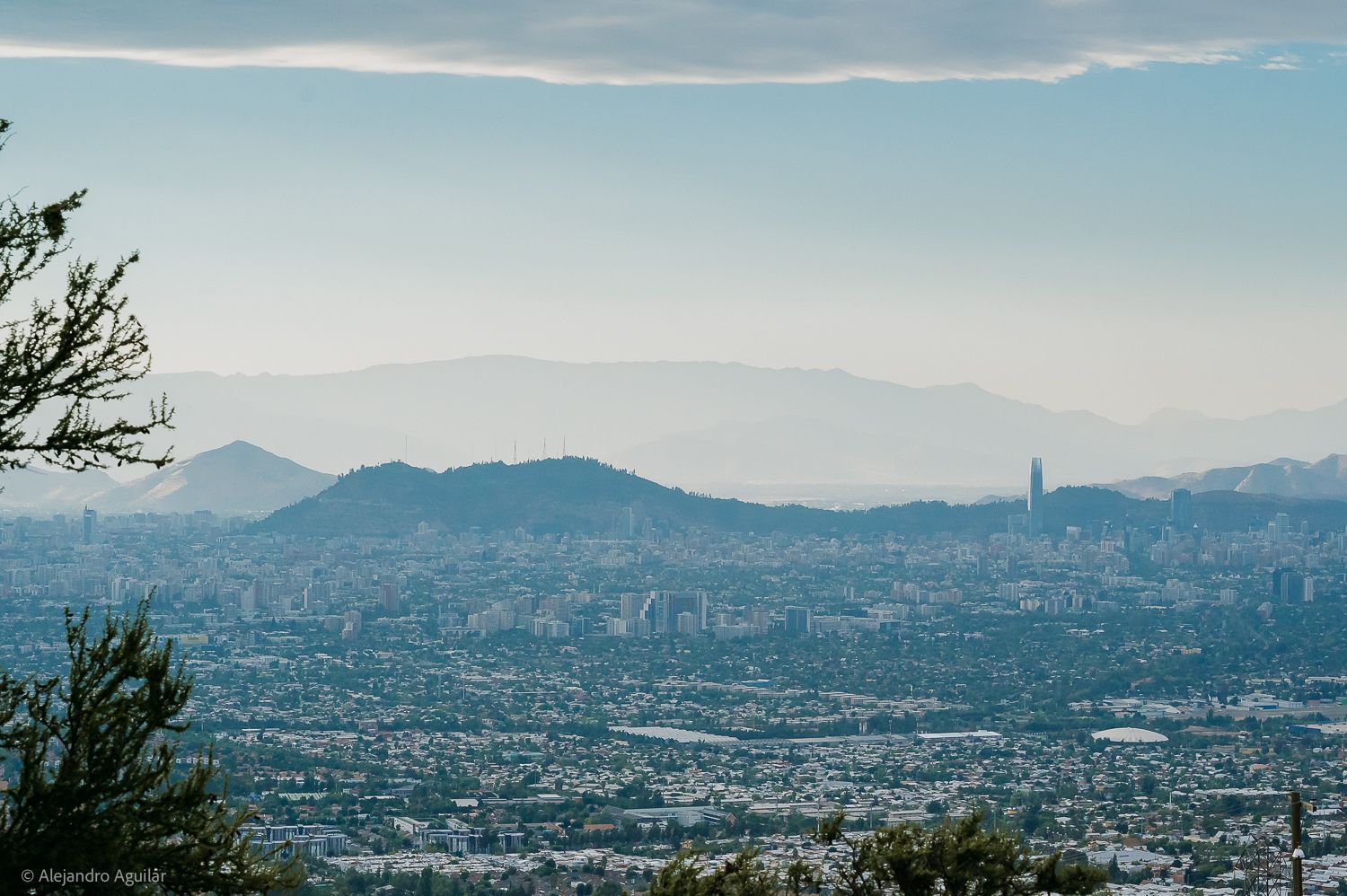 Aerial panoramic view of Santiago, Chile cityscape with Andes Mountains and Gran Torre skyscraper in the background.