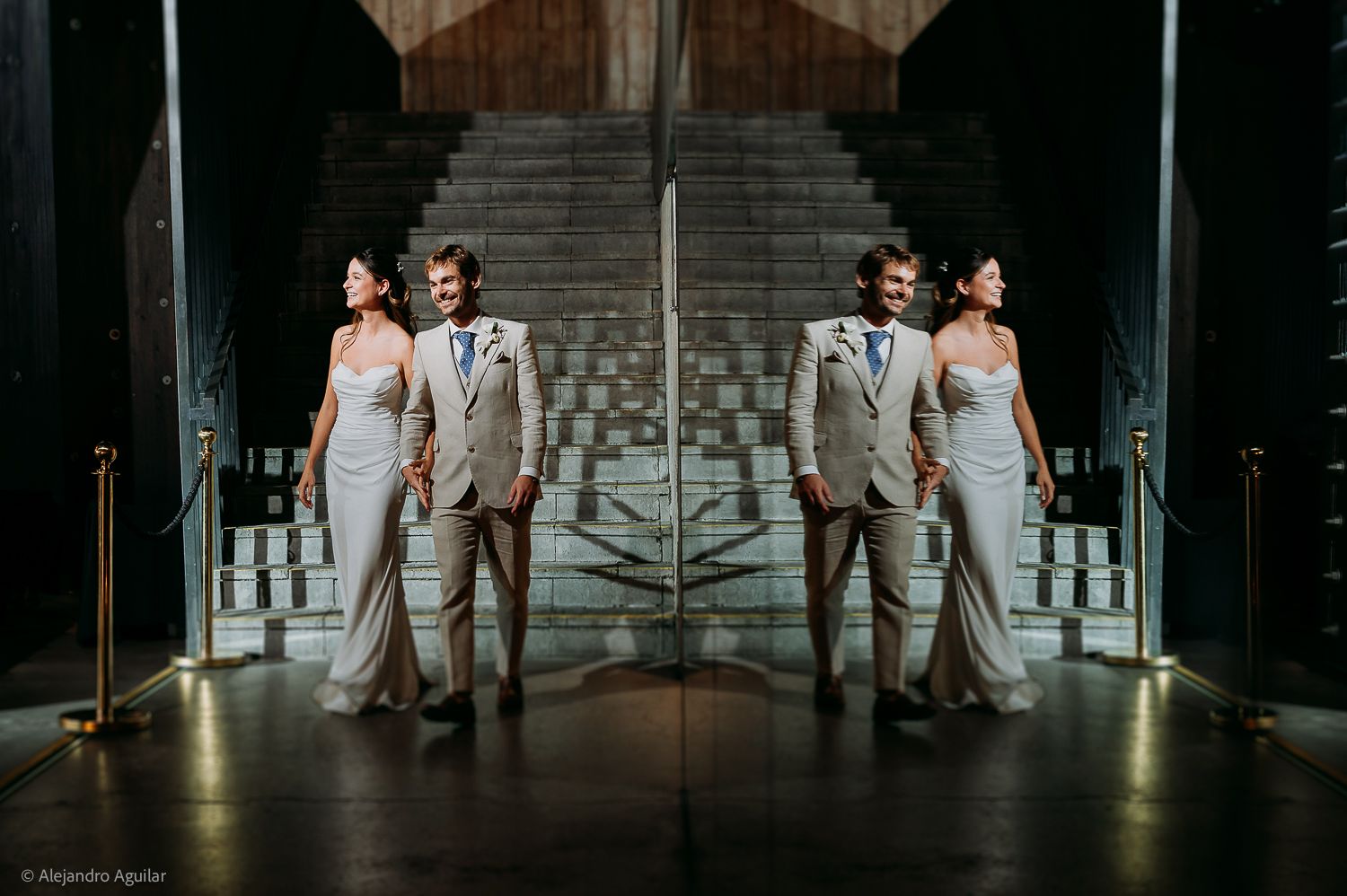 Mirrored wedding photo of a couple in elegant attire on grand staircase, creating a symmetric reflection effect.