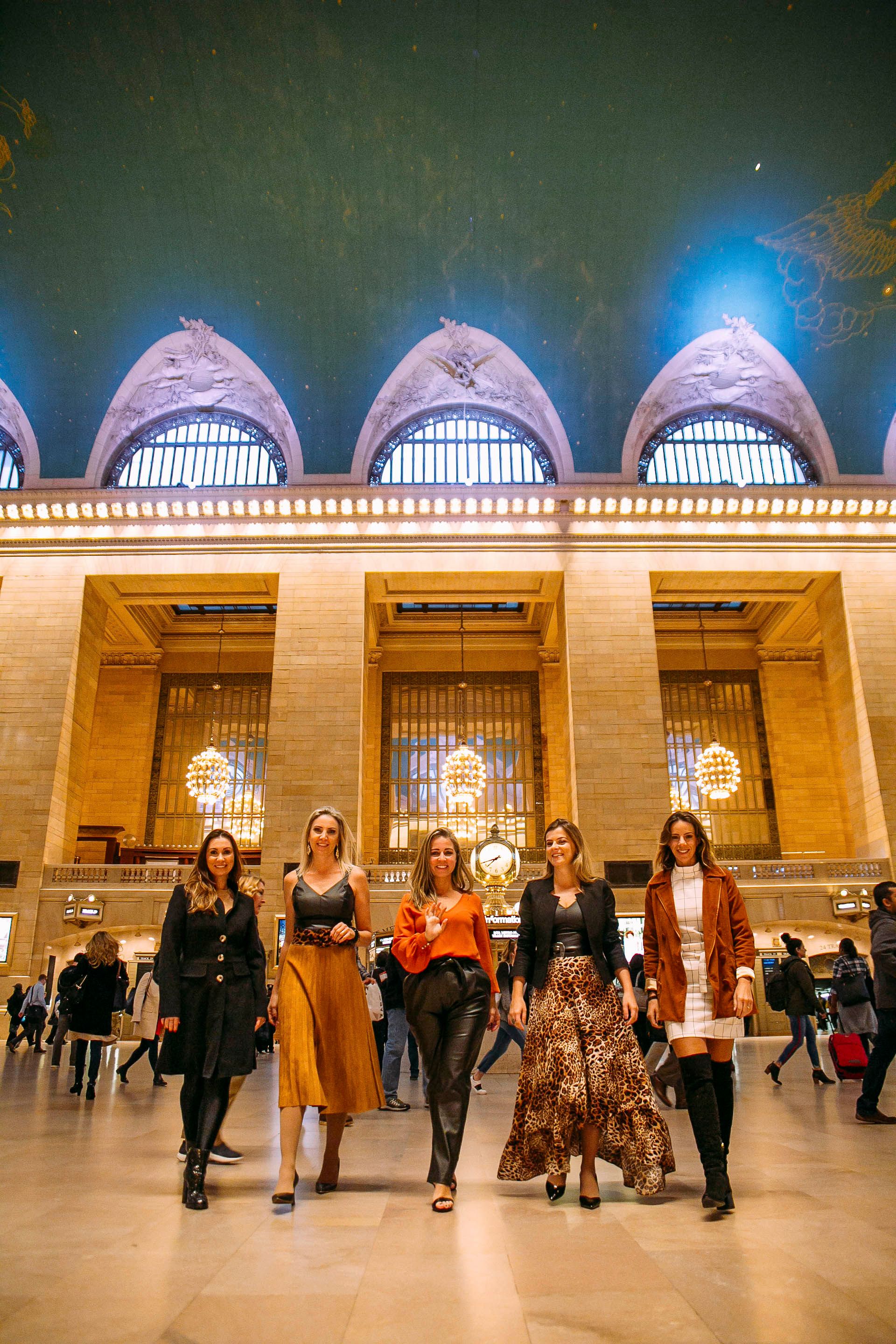 Group poses in elegant outfits inside Grand Central Terminal's iconic architecture.