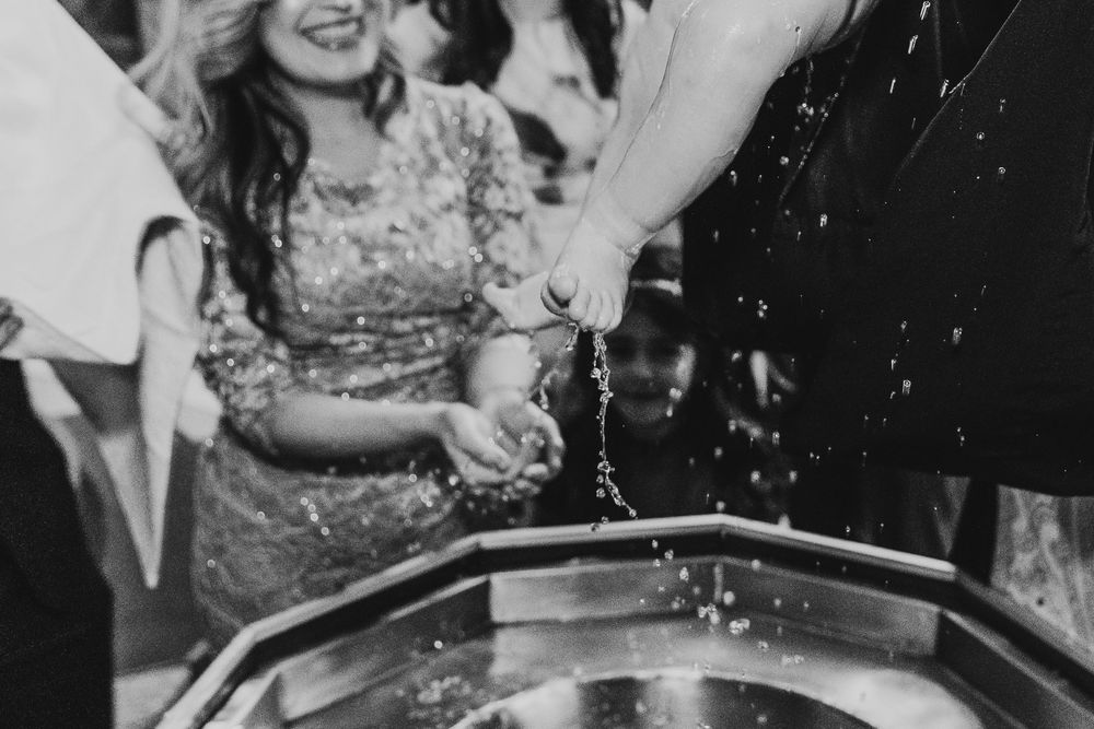 Black and white photo of guests pouring champagne into a fountain at a wedding reception celebration.