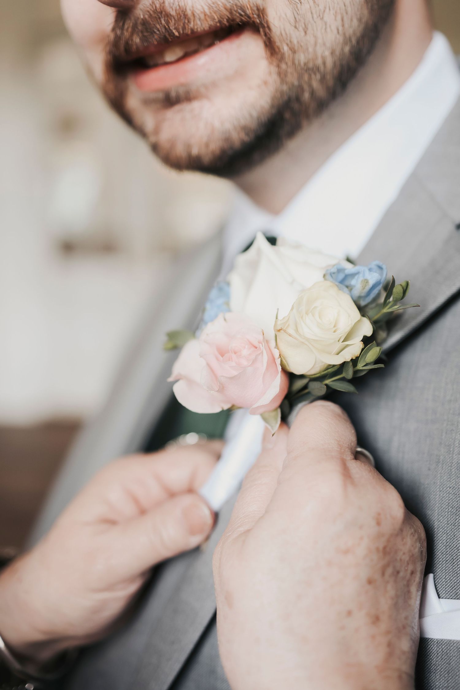 Mother of the groom pinning Parker’s boutonniere before the ceremony