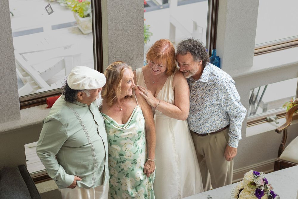 Karen and George celebrating their wedding day with their two close friends
