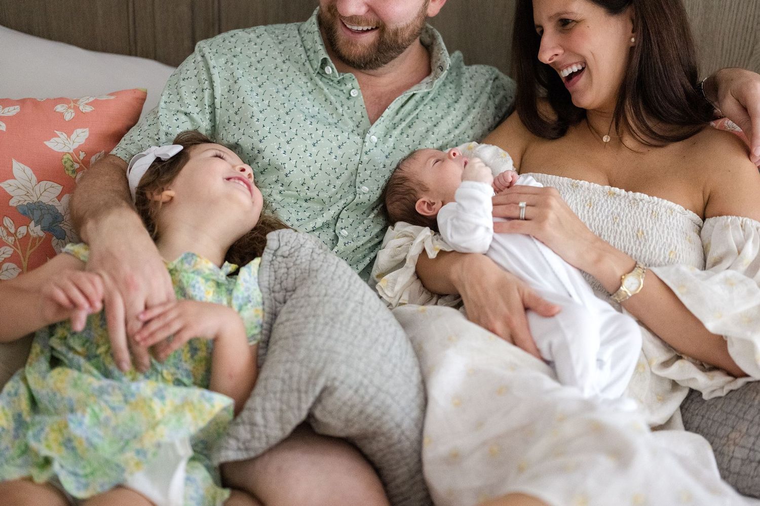Big sister looking at her new baby sibling during newborn pictures at home
