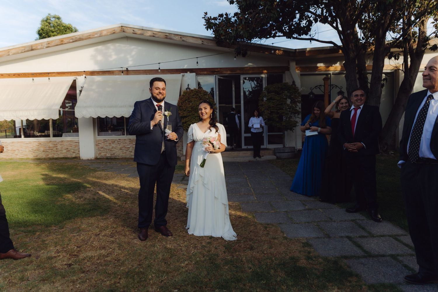 Bride and groom standing together during their outdoor wedding ceremony near a venue.