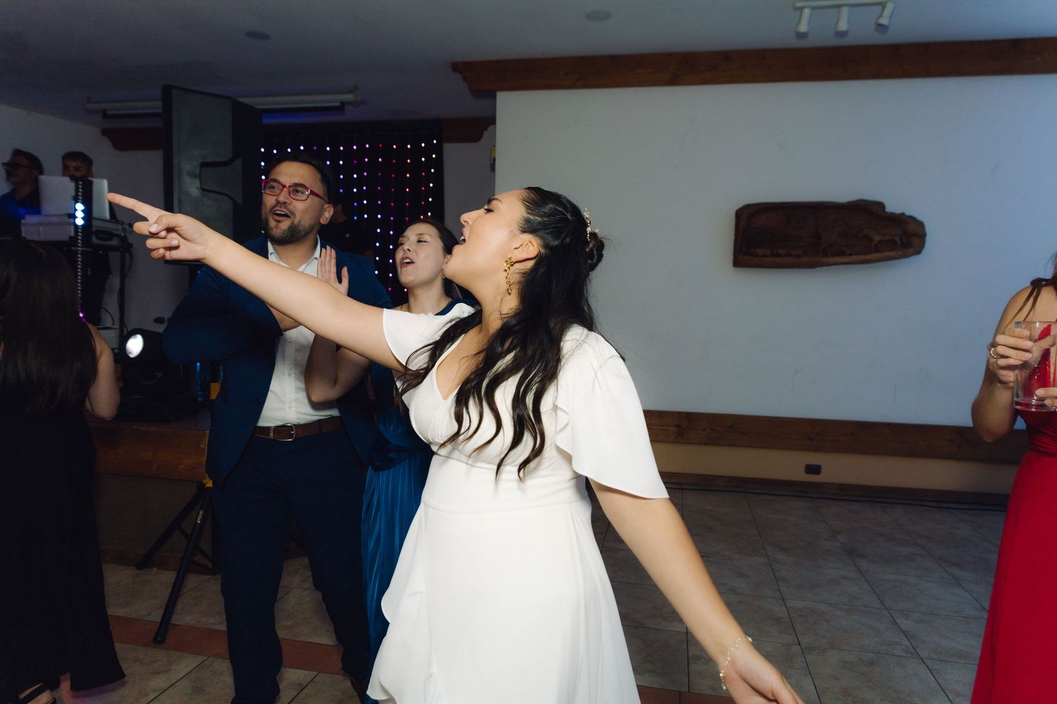 Bride and groom dancing and pointing joyfully on the dance floor at their wedding reception.