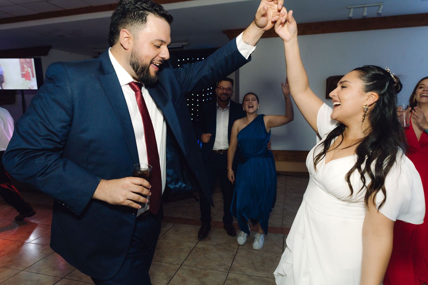 Bride and groom spin together joyfully on the dance floor at their lively wedding reception.
