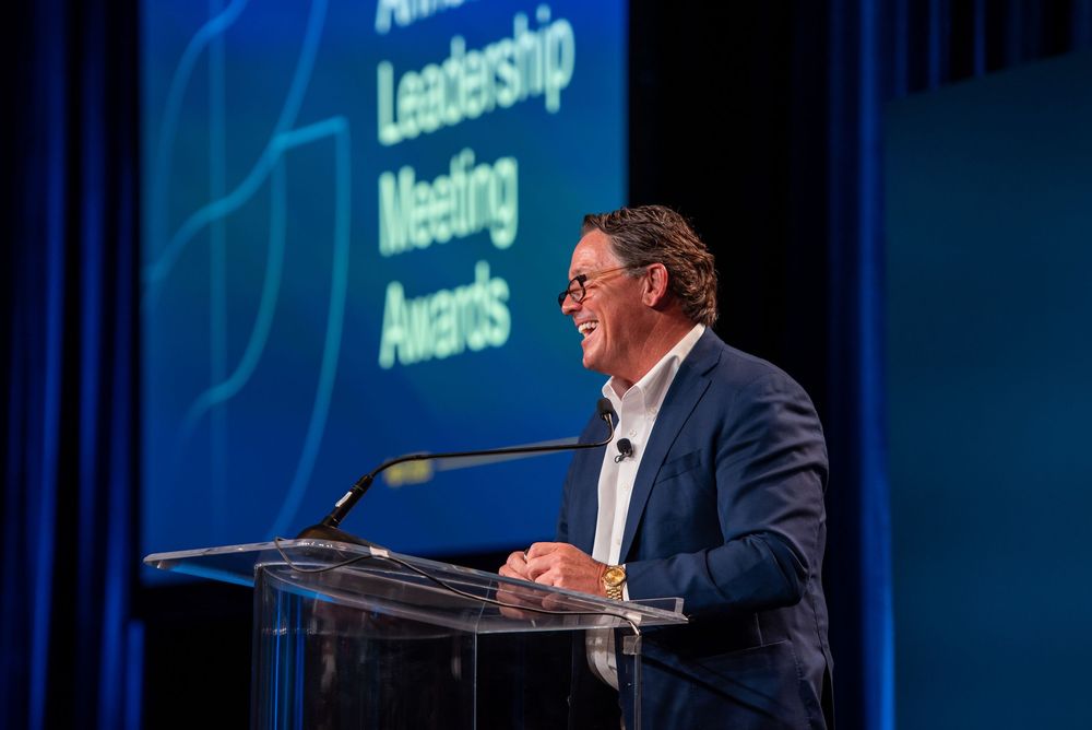 Keynote speaker on stage during a leadership meeting.