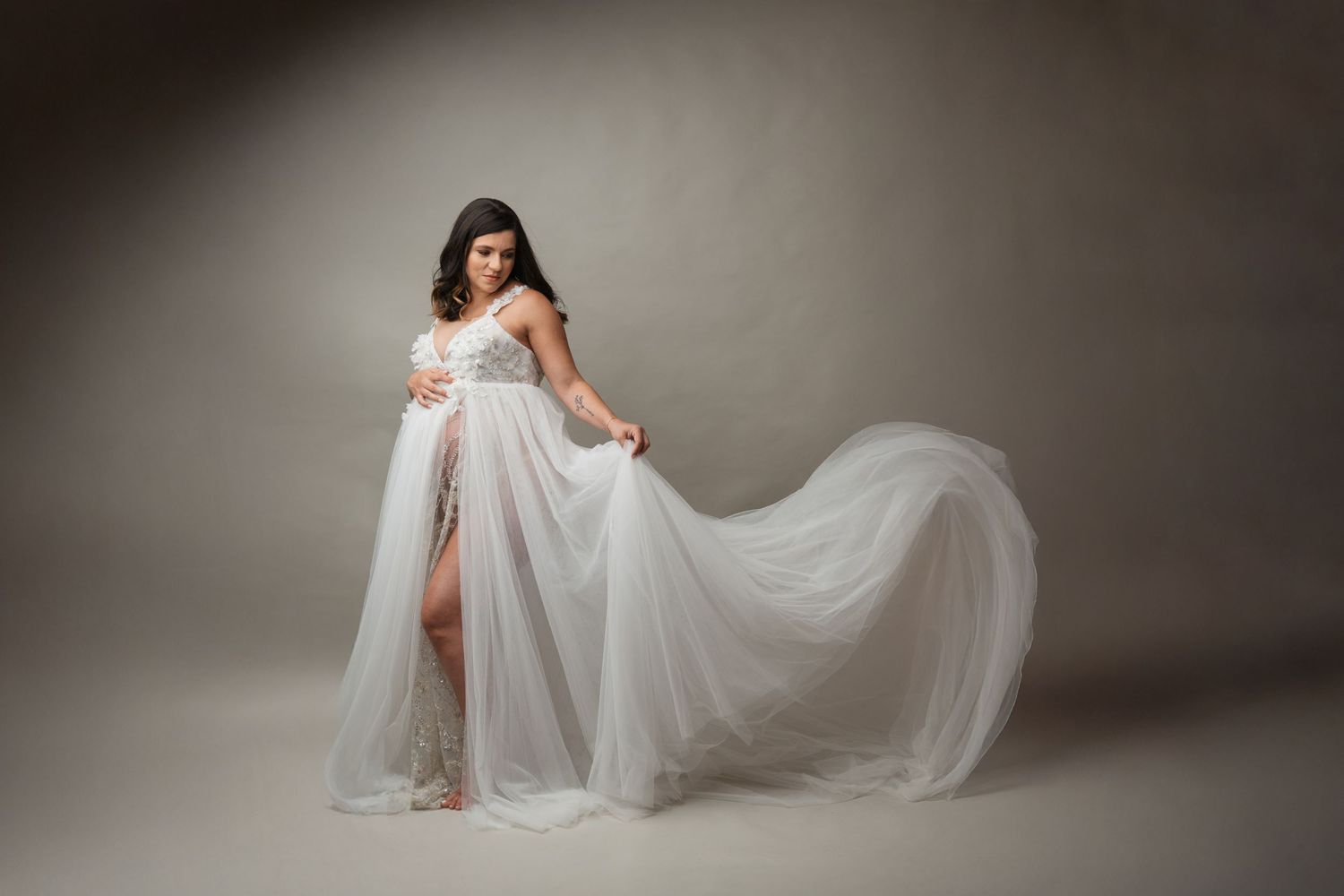 Pregnant mother in a flowing white maternity gown during a studio maternity photography session in Linden, New Jersey.