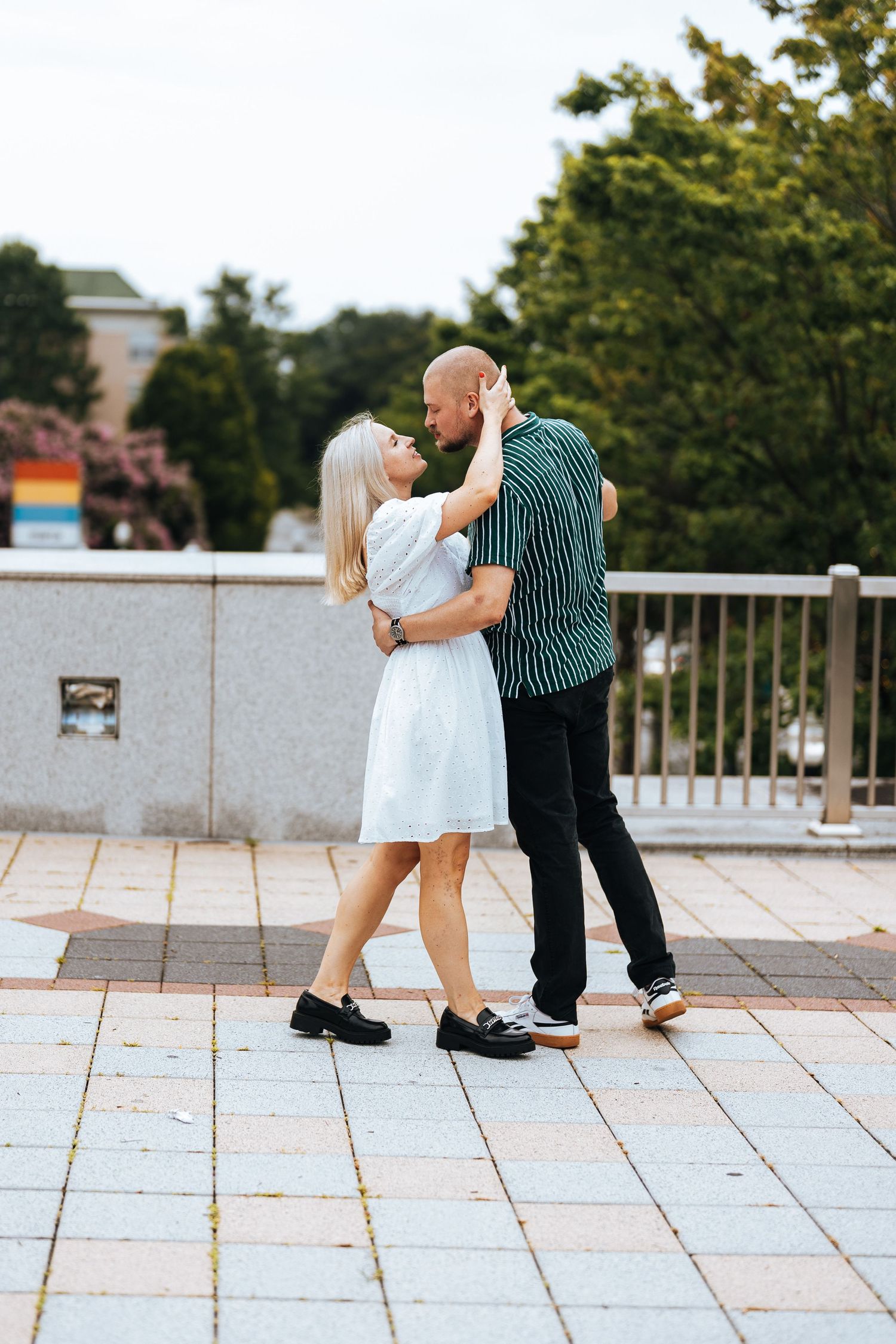 A couple dancing together on a stone patio in a romantic sequence of dance moves.