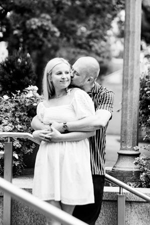 A series of black and white photographs showing two people embracing in a garden setting.