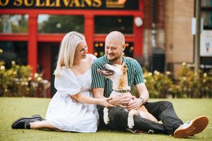 Couple sitting on grass in a park having a casual outdoor picnic together.