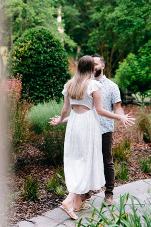 engaged couple holding hands in the garden
