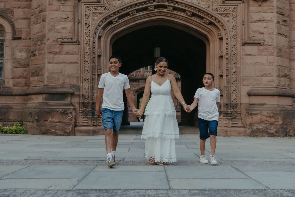 Mom and two boys posing under a gothic arch during a Princeton, NJ family session