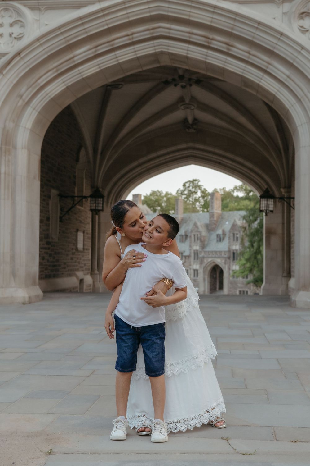 Mom lifting her son for a hug in a Princeton archway, natural family photography in New Jersey