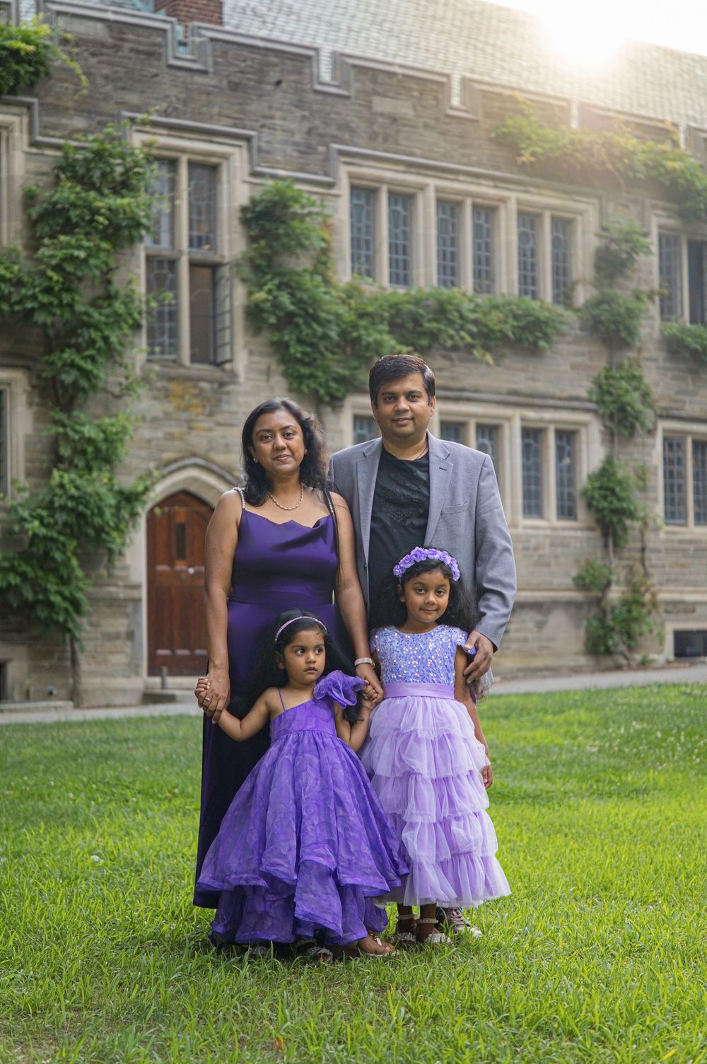 Family posing in front of ivy-covered stone walls at golden hour, Princeton family photo session