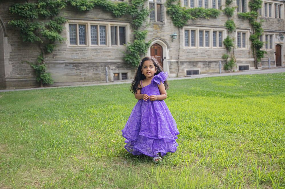 Little girl twirling in a purple tulle dress on the grass at Princeton, NJ family photography