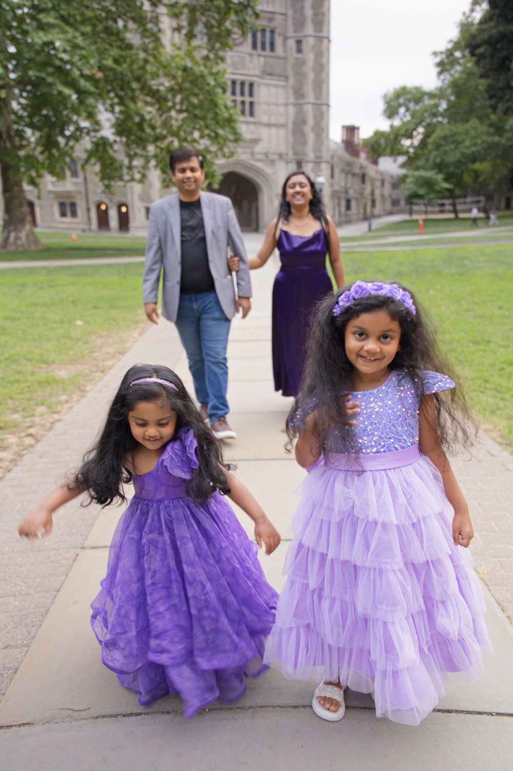 Two sisters in purple dresses walking with their parents at Princeton University, NJ family photography