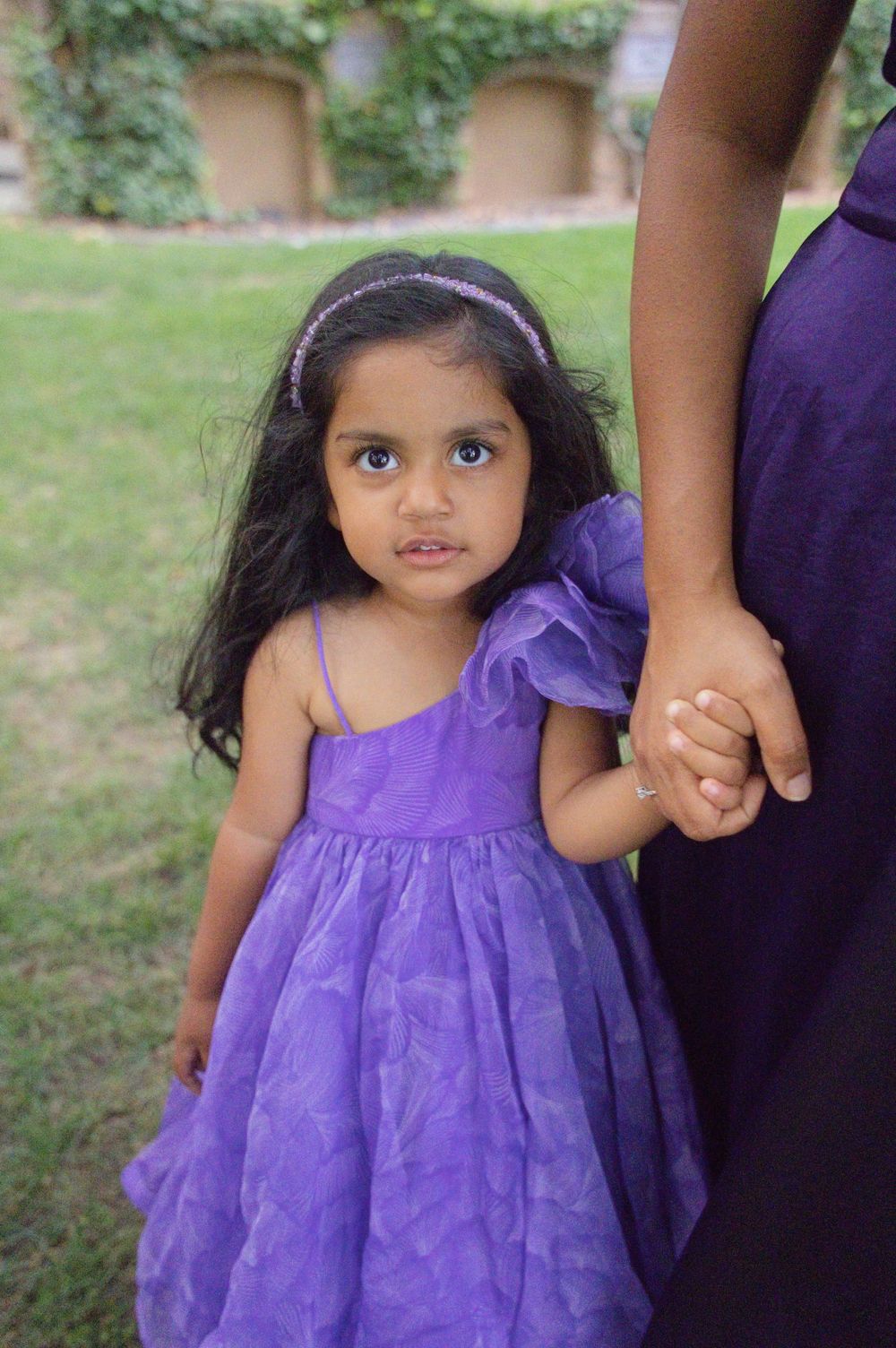 Little girl in a purple tulle dress holding her mother's hand during a Princeton family photo session