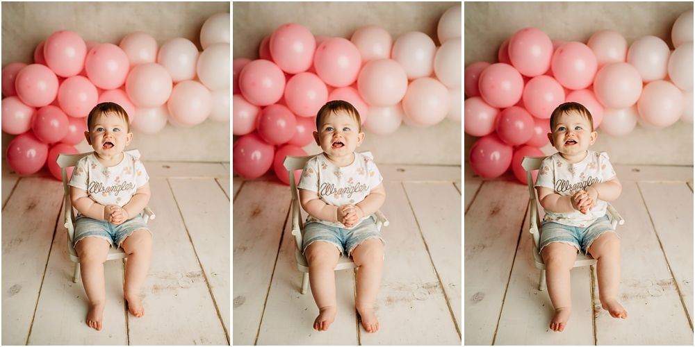 Baby girl sits on wood floor against pink balloon backdrop in a triptych first birthday cake smash photo session.