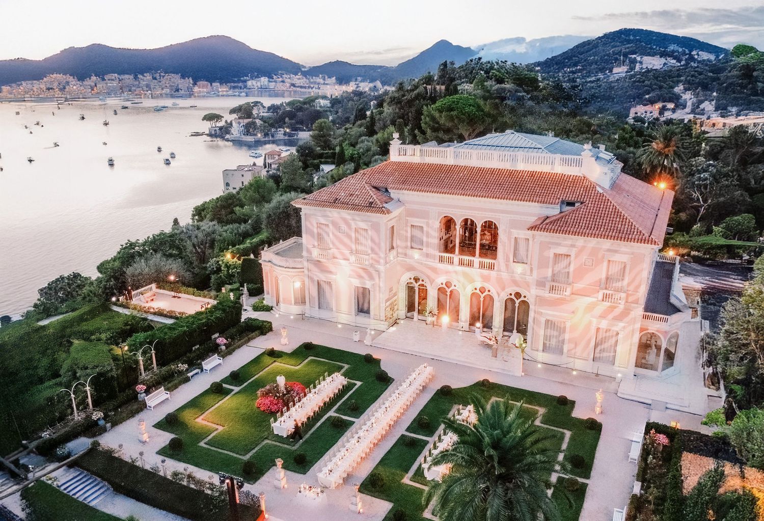 Aerial view of a luxurious Villa Ephrussi de Rothschild Wedding overlooking a the Mediterranean Sea at dusk.