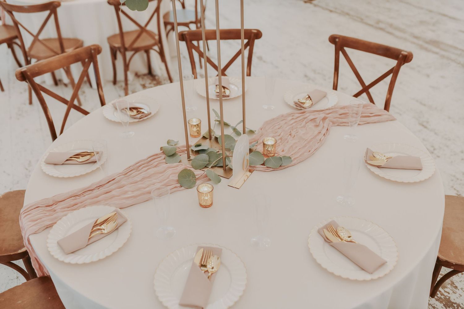 White rustic wedding reception featuring farmhouse chairs and soft mauve table accents