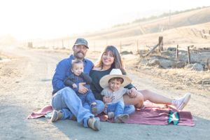 Heartwarming scene of a family, such as parents and children, smiling and laughing together, captured in a natural light setting with a clea