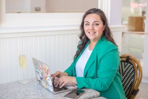Professional headshot of a person in a business setting, featuring a clean background and natural light.