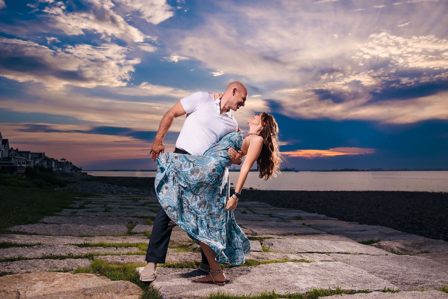The bride and groom to be share a passionate dance during their engagement session over looking the Atlantic ocean