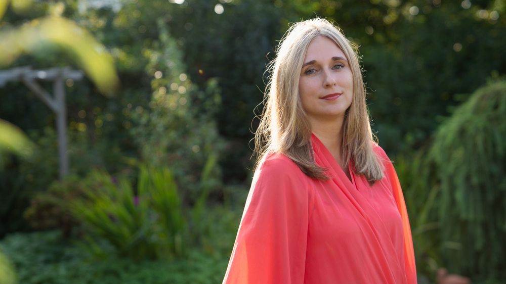 Professional portrait of a woman in a garden in Zonhoven, exuding confidence and elegance in a natural setting.