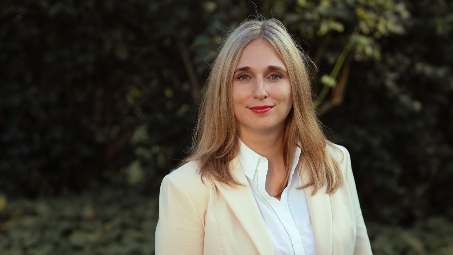 Professional portrait of a woman in a business suit, looking confident and polished in a studio setting.