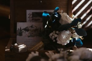 A moody wedding detail shot of a blue and white floral bouquet with dramatic lighting and shadows.
