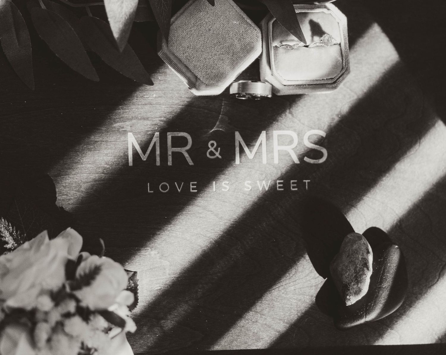 Black and white photo of 'MR & MRS' text with shadows casting dramatic lines across the surface.